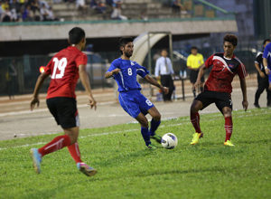 The Matao's Ian Adamos looks to pass the ball as Cambodia defenders Tieng Tiny (19) and Prak Mony Udom (7) begin to converge on him during a FIFA international friendly match at the Olympic Stadium in Phnom Penh Tuesday. Guam shut out Cambodia 2-0 in the contest.