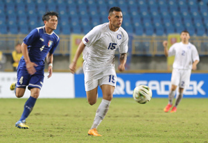 Guam's Shawn Nicklaw looks to pass the ball forward after outpacing Chinese Taipei's Huang Wei Ming during an opening day match of the EAFF East Asian Cup semifinal round at the Taipei Municipal Stadium in Taipei City. Guam defeated Chinese Taipei 2-1.