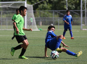 The Guam Shipyard Wolverines' John Topasna slides in to try to clear the ball away from Tan Holdings FC's Taka Borja of the Northern Mariana Islands in an opening day U14 division match of the Youth Invitational Gobblefest soccer tournament at the Guam Football Association National Training Center Friday. The Wolverines won 4-2.