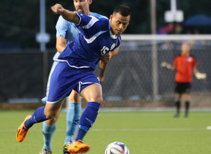 Guam's Shawn Nicklaw gets held back by the Northern Mariana Islands' Nicolas Swaim en route to the goal during a match of the EAFF East Asian Cup Round 1 Friday at the Guam Football Association National Training Center. Guam blanked NMI 5-0 to advance to the tournament semifinal round for the third-straight time.
